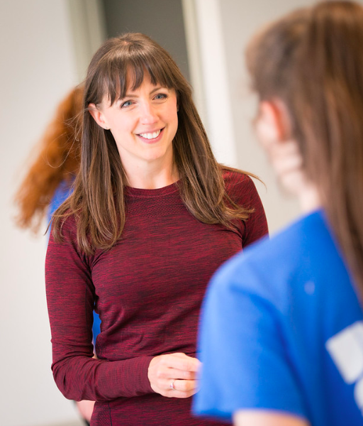 Image of woman with long brown hair wearing a red top