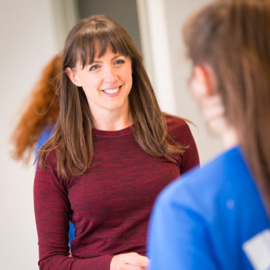 Image of woman with long brown hair wearing a red top