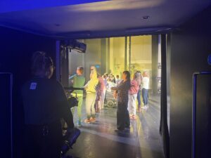 View from the side of stage, several people are visible from the side.