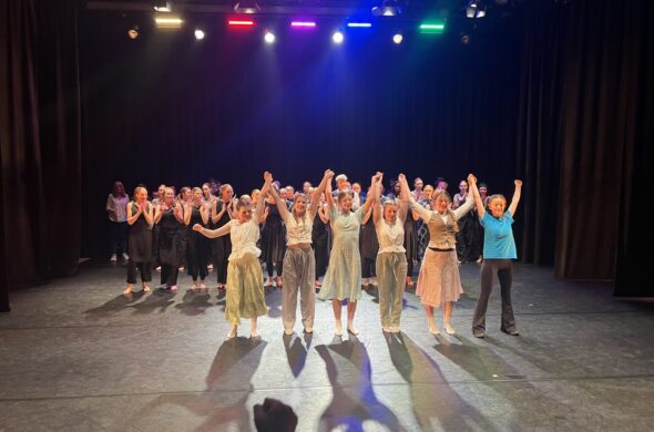 Lots of young people on a stage. 6 are near the front taking a bow.