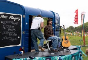 Two men on a small stage and a guitar