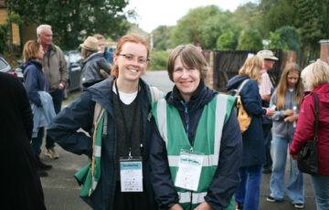 An older woman with short grey hair and a younger woman with tied back ginger hair pose for a photo.
