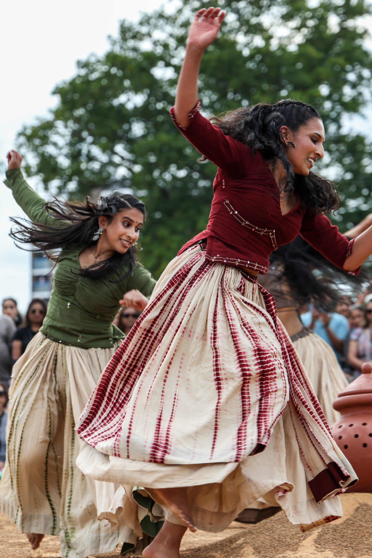 Two females dancing in green and red clothing