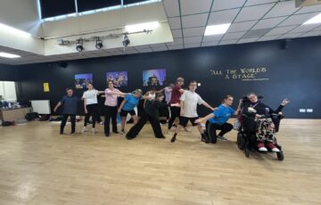 A group of dancers create a line and lean on one another